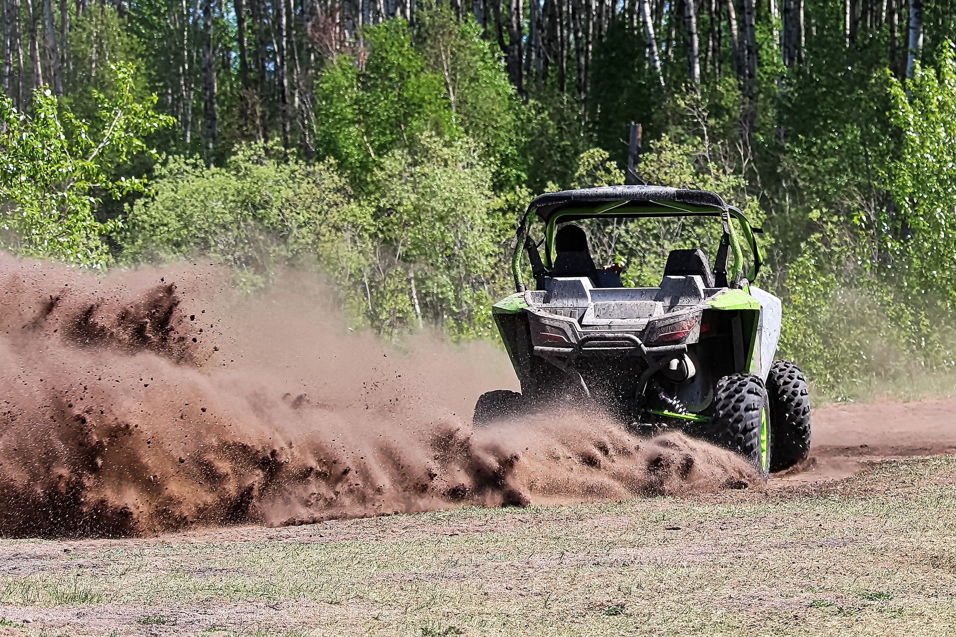 A side-by-side ripping up dirt as it turns a corner